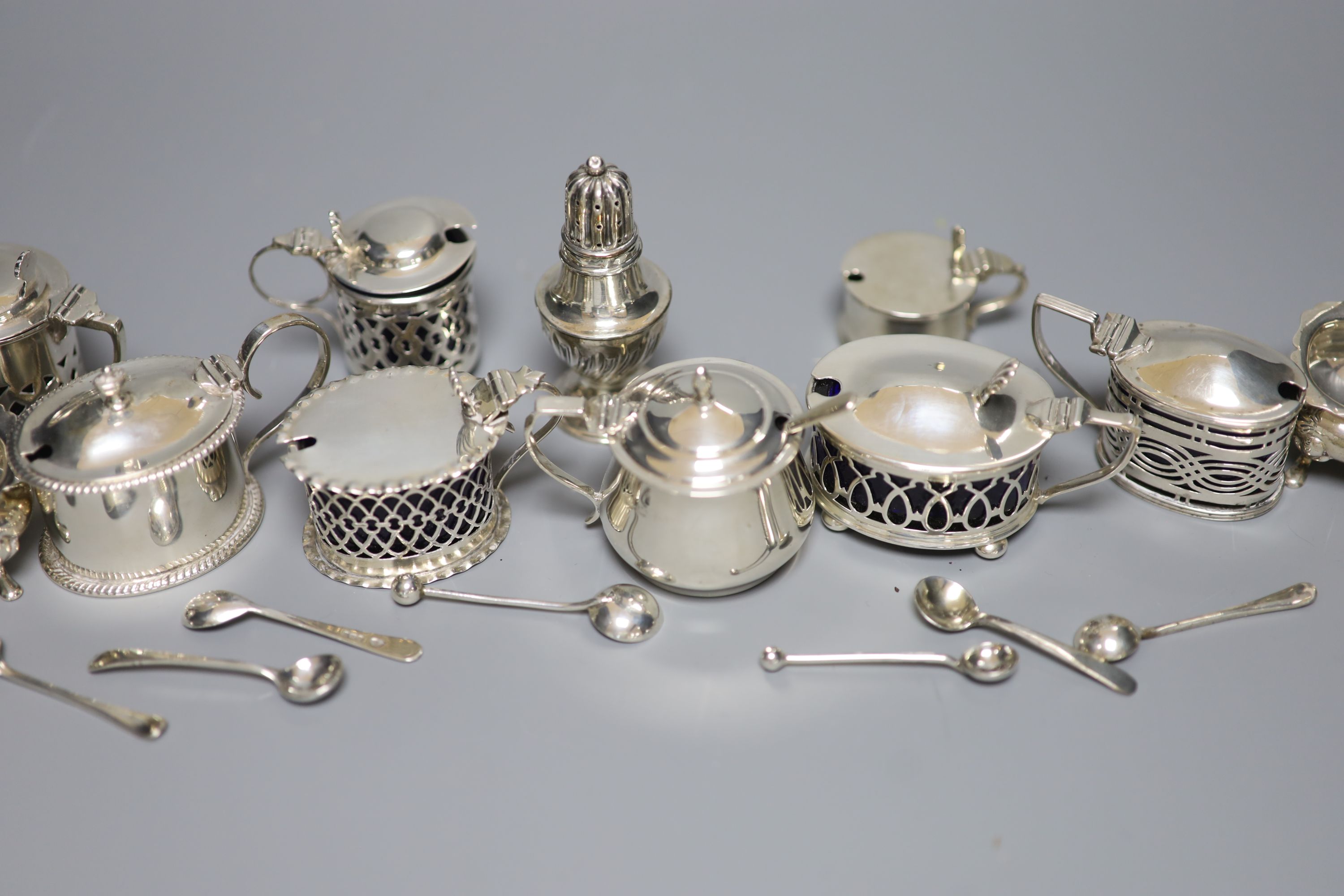 A pair of oval silver salts and spoons, nine small silver mustards, a pepper and seven various condiment spoons, approx 11.5oz